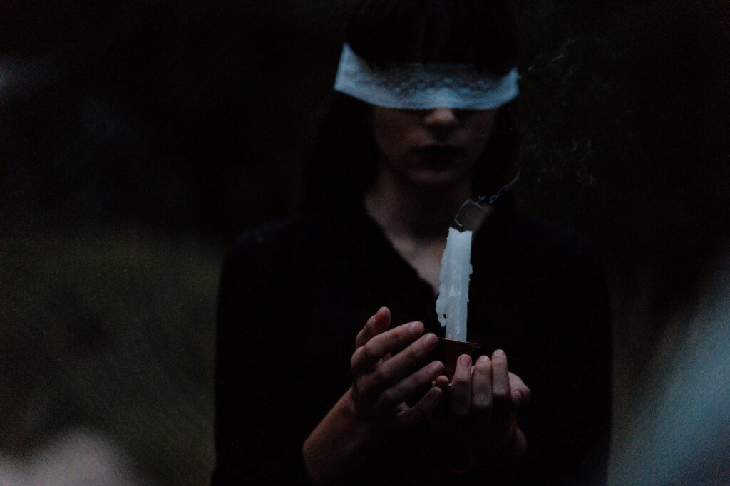 blindfolded woman with a candle